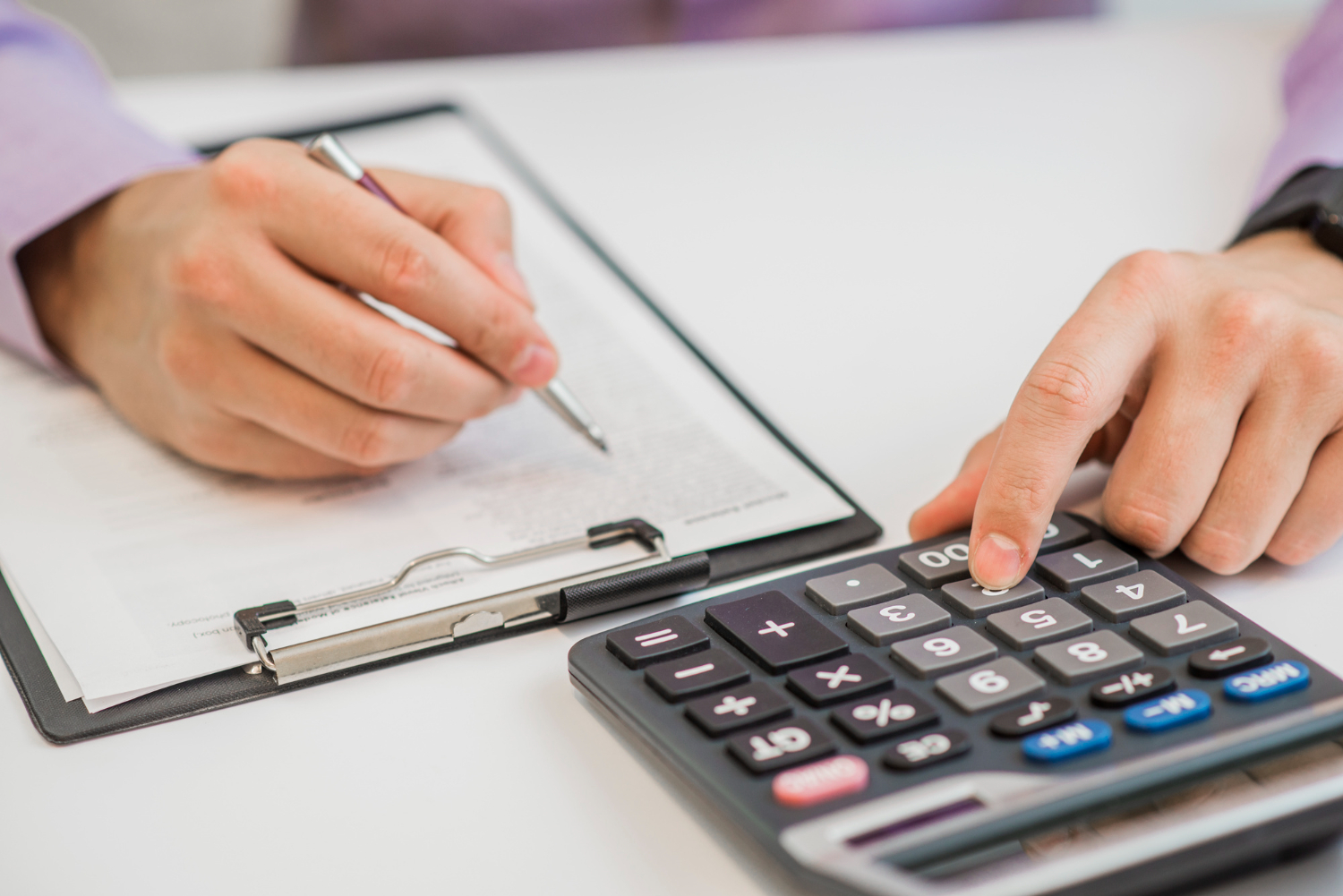 close-up-businessman-calculating-invoices-using-calculator